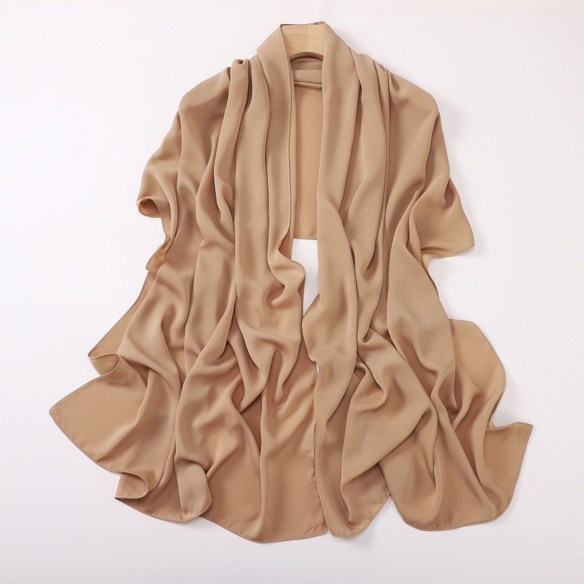 Beige scarf draped over a white background