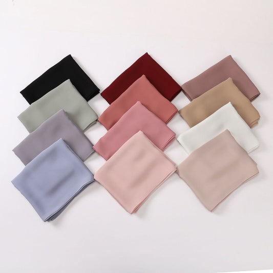 Collection of folded fabric swatches in various colors on a white background