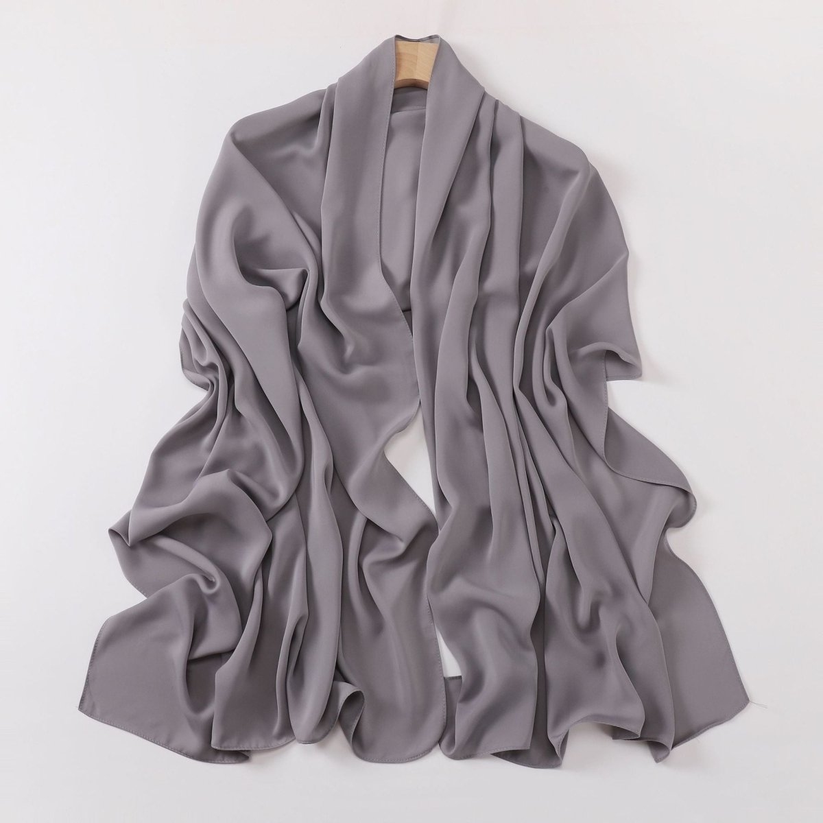 Gray scarf draped over a mannequin on a white background